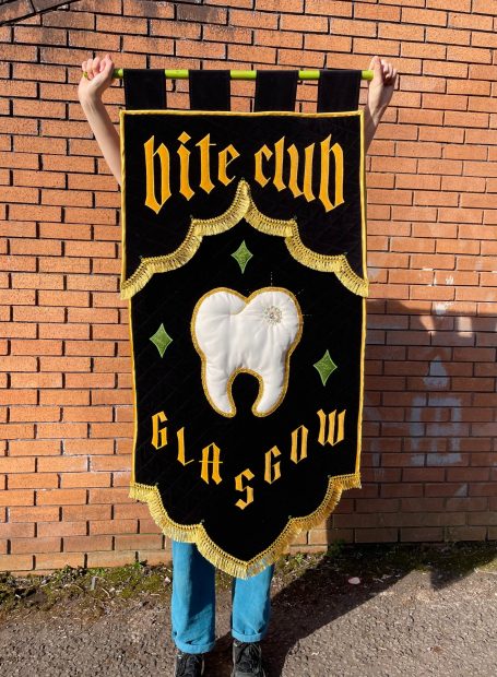'Bite Club Glasgow' Handmade Fabric Banner - Ellietype 'Bite Club Glasgow' handmade fabric banner for tattoo convention, held up by Ellietype